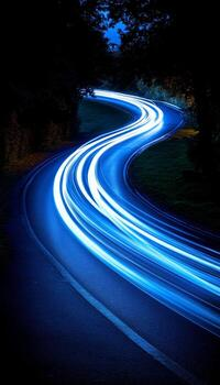 Blue light trails on a winding road at night